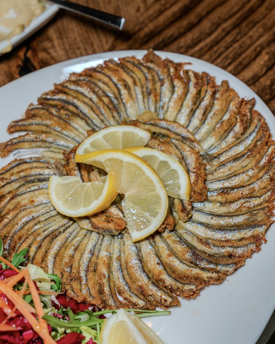 Anchois frits disposés en rosace avec citron